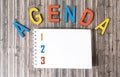 Agenda word made from wooden letters, next to notepad Royalty Free Stock Photo