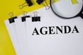 Agenda word written on white piece of paper and yellow background Royalty Free Stock Photo