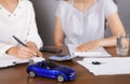 Agent car salesman informs about the car purchase contract. Two women