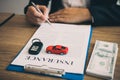 Agent is signing the insurance contract for the car at the document on the desk Royalty Free Stock Photo