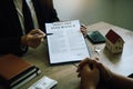 Agents are using pens pointing to insurance contracts and are being explained to customers at the office