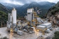 This aggregate processing plant, surrounded by mountains, efficiently transforms raw materials into essential construction Royalty Free Stock Photo