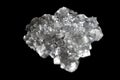 Aggregate of transparent cubic salt crystals isolated on a dark background