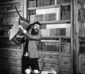 Aggression, hate, nervous, negative emotions concept. Man with angry face holds chair and ruins library. Bearded man in