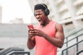 Aggressive african american guy in headphones screaming into the phone against the backdrop of the city, angry annoyed man looking Royalty Free Stock Photo