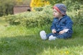 Aggressive angry baby boy is sitting on the grass Royalty Free Stock Photo