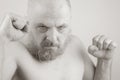 Aggressive bearded man with clenched fists in black and white photo portrait