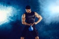 Aggressive bearded muscular bodybuilder doing Exercise for the biceps with kettlebell. Studio shot Royalty Free Stock Photo