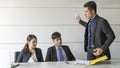 Aggressive boss businessman holding paper file work and complain staff and colleague in meeting conference room Royalty Free Stock Photo