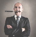 Aggressive businessman with knife between teeth