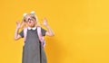 Aggressive elementary school girl showing negative emotions on a yellow background Royalty Free Stock Photo