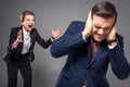 aggressive female boss yelling at frightened businessman,