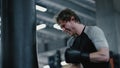 Aggressive kickboxer showing strength at gym. Sportsman boxing in sport club