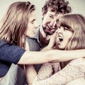 Aggressive mad women fighting over man. Royalty Free Stock Photo