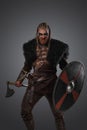 Aggressive viking with shield and axe dressed in black fur