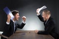 Aggressive Young Businessmen Arguing At Desk