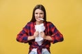 Aggressive young caucasian woman tears contract or white sheet of paper. Isolated over yellow background. Royalty Free Stock Photo