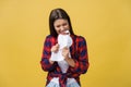 Aggressive young caucasian woman tears contract or white sheet of paper. Isolated over yellow background. Royalty Free Stock Photo