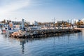 AGIA NAPA, CYPRUS - April 3, 2016: Entrance to the little port with fishing and cruise boats, people resting near the beacon Royalty Free Stock Photo