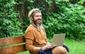 Agile business. Bearded guy sit on bench in park nature background. Work and relax. Fresh air. Mobile internet. You can Royalty Free Stock Photo