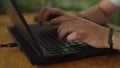 Close-up of coders hands typing on laptop, programming in a tech environment. Agile fingers navigate the keyboard