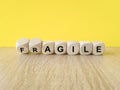Agile or fragile symbol. Concept words Agile and Fragile on wooden cubes. Beautiful wooden table yellow background. Business agile