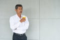 Aging businessman or retirement man have a good health drinking organic and fresh orange juice and thinking seriously Royalty Free Stock Photo