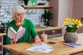 Aging grandmother concernedly looking at vedic drawing at kitchen room