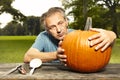 Aging man in city park working on helloween pumpkin Royalty Free Stock Photo