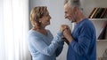 Aging man holding ladys hands, preparing to kiss them, lady being shy, coquette Royalty Free Stock Photo