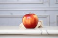 aging red apple with a bruised side on a marble surface