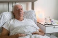 Aging senior man male bed sick ill alone retired resting unhappy sad sleeping Royalty Free Stock Photo