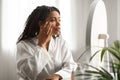 Aging Signs. Stressed Black Woman Touching Face Skin And Looking At Mirror Royalty Free Stock Photo