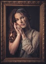 Aging, skin care concept. Half old half young woman with picture frame. Royalty Free Stock Photo