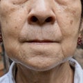 Aging skin folds or skin creases or wrinkles at face of Asian, Chinese old woman