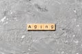 Aging word written on wood block. Aging text on cement table for your desing, concept Royalty Free Stock Photo