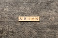 Aging word written on wood block. Aging text on cement table for your desing, concept Royalty Free Stock Photo
