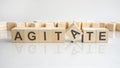 agitate text on a wooden blocks, gray background. Royalty Free Stock Photo
