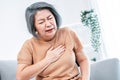 An agonizing elderly woman is experiencing chest pain.
