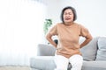 An agonizing senior woman experiencing back pain.