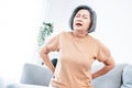 An agonizing senior woman experiencing back pain.