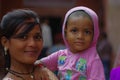 Agra, India - September 20, 2017: Portrait of a beautiful teenager holding her little sister in their arms, looking at