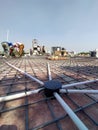 Agra- up- India- November 4, construction on the roof top, iron rod and electronic pipe spread all over the roof, people working