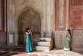 An Asian woman takes a picture of another woman inside the Taj Mahal