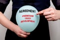 Agreement. Friendship, Trust and Development concept. Woman explodes a balloon with a needle Royalty Free Stock Photo