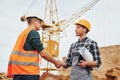 Agreement is successful. Two construction workers in uniform and safety equipment have job on building together Royalty Free Stock Photo