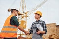 Agreement is successful. Two construction workers in uniform and safety equipment have job on building together Royalty Free Stock Photo