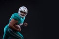 Agressive American football sportsman player on black background running in action. Sport wallpaper Royalty Free Stock Photo