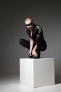 Agressive bald sitting woman with mask makeup