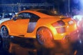 Agressive and brutal orange sport car on rained road picture useful for background Royalty Free Stock Photo